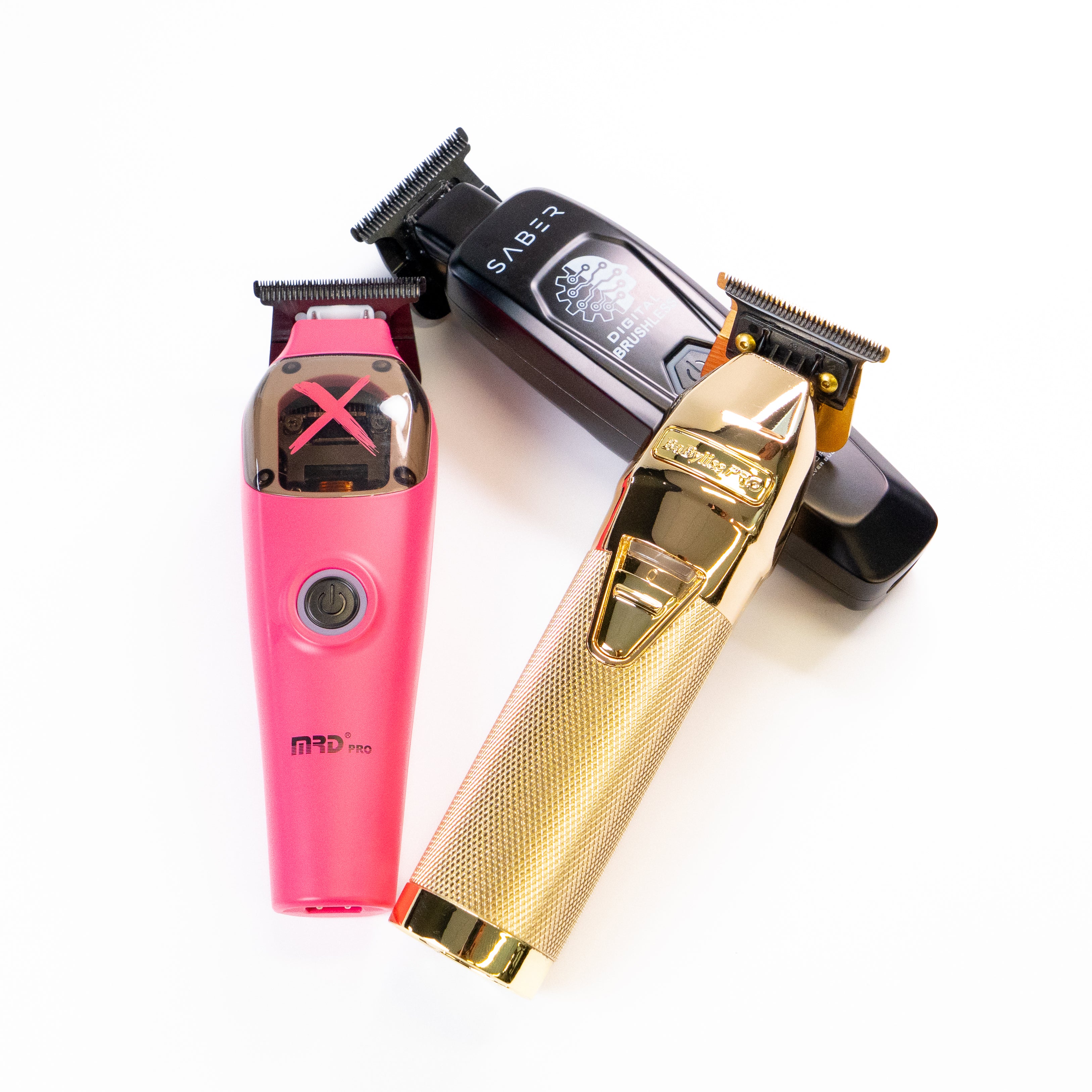 Three hair trimmers in pink, black, and gold on a white background